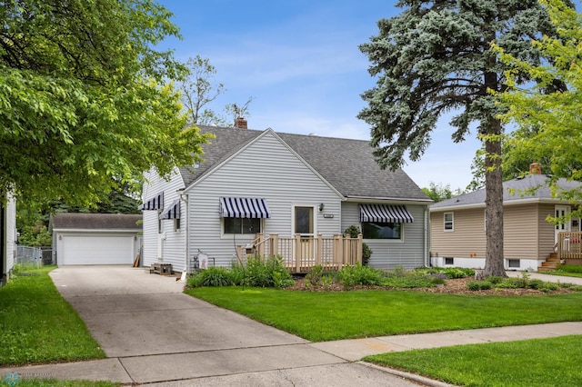 1109 14th St N, Moorhead, MN 56560 - view of front of house featuring an outdoor structure, roof with shingles, a front lawn, a chimney, and a detached garage