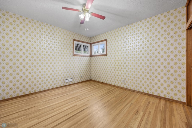 1109 14th St N, Moorhead, MN 56560 - unfurnished room featuring light wood-type flooring, wallpapered walls, a textured ceiling, and a ceiling fan