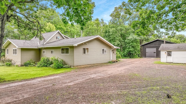 14645 Chapel Rd, Edgewater, WI 54817 - view of property exterior featuring driveway, an outbuilding, a garage, and roof with shingles