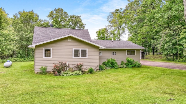 14645 Chapel Rd, Edgewater, WI 54817 - view of side of home with a lawn, a shingled roof, and asphalt driveway