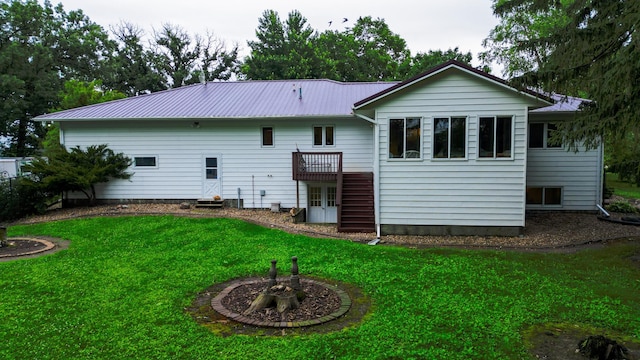 26233 555th Ave, Lansing Twp, MN 55912 - rear view of house with a lawn, a metal roof, a deck, and french doors