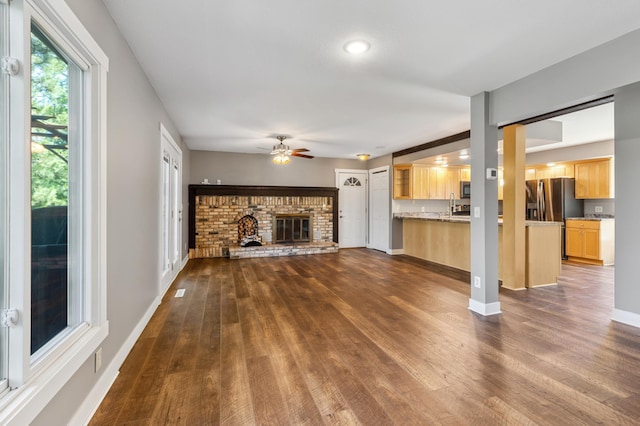27088 130th St, Staples, MN 56479 - unfurnished living room featuring dark wood-style flooring, a fireplace, and ceiling fan