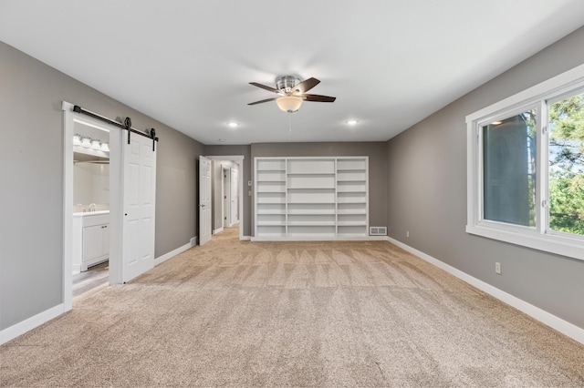 27088 130th St, Staples, MN 56479 - unfurnished bedroom with a barn door, light colored carpet, a ceiling fan, ensuite bath, and recessed lighting