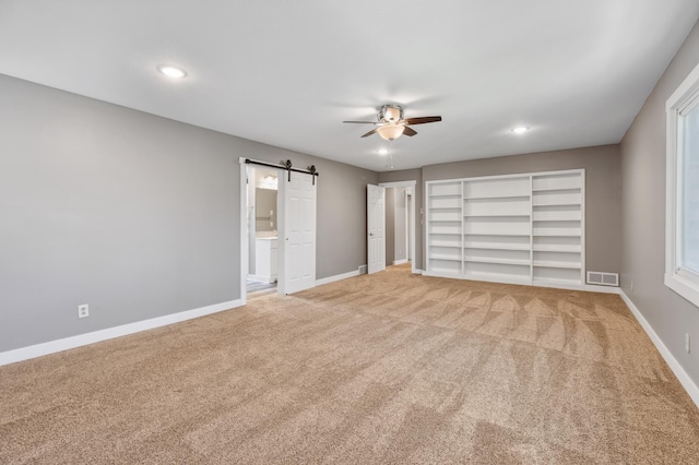 27088 130th St, Staples, MN 56479 - unfurnished bedroom with light colored carpet, a barn door, recessed lighting, connected bathroom, and ceiling fan
