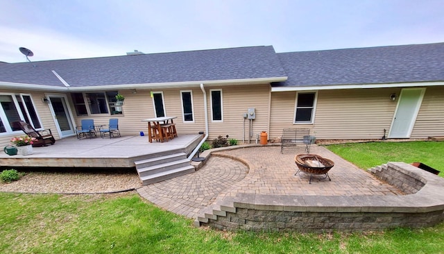 N5887 1110th St, Oak Grove Twp, WI 54021 - rear view of property featuring an outdoor fire pit, a deck, a shingled roof, and a lawn