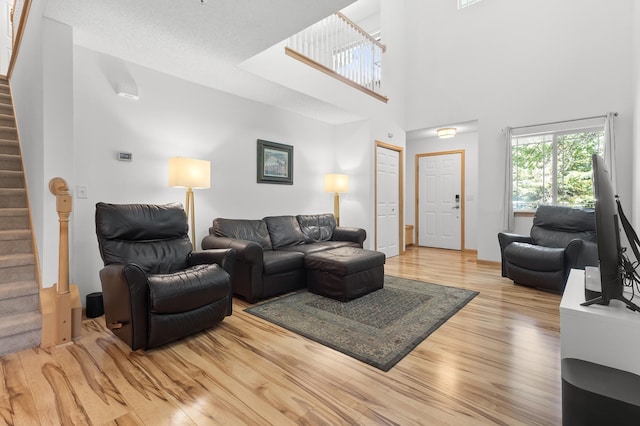 14939 Pinto Ln, Savage, MN 55378 - living room featuring stairway, light wood finished floors, and a high ceiling