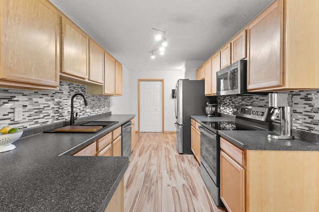 14939 Pinto Ln, Savage, MN 55378 - kitchen featuring stainless steel appliances, light brown cabinetry, dark countertops, decorative backsplash, and light wood finished floors