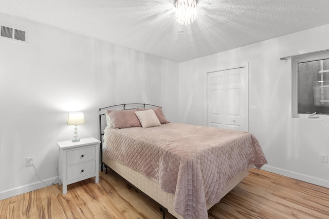 14939 Pinto Ln, Savage, MN 55378 - bedroom with light wood-style floors, a closet, and a textured ceiling