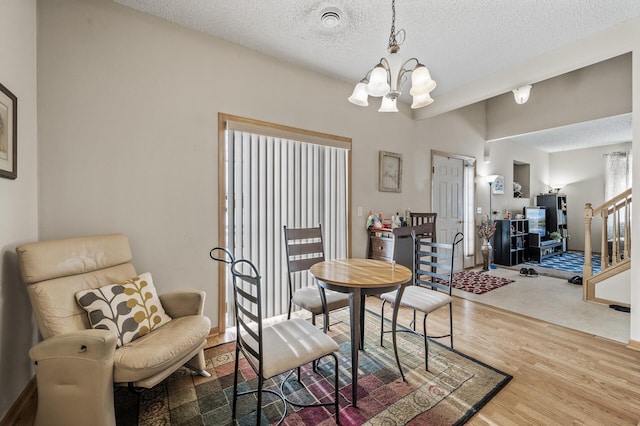 6566 Merrimac Ln N, Maple Grove, MN 55311 - dining room featuring wood finished floors, a chandelier, a textured ceiling, and stairs
