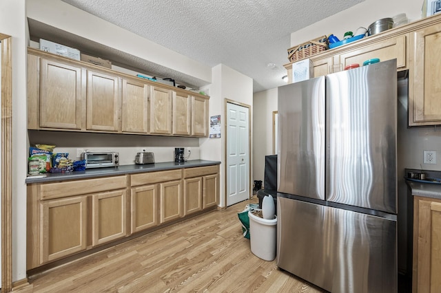 6566 Merrimac Ln N, Maple Grove, MN 55311 - kitchen with freestanding refrigerator, light brown cabinetry, light wood-type flooring, dark countertops, and a textured ceiling