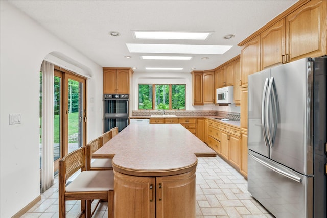 3718 Big Mcgraw Rd, Blaine Twp, WI 54830 - kitchen featuring appliances with stainless steel finishes, a center island, plenty of natural light, a skylight, and recessed lighting