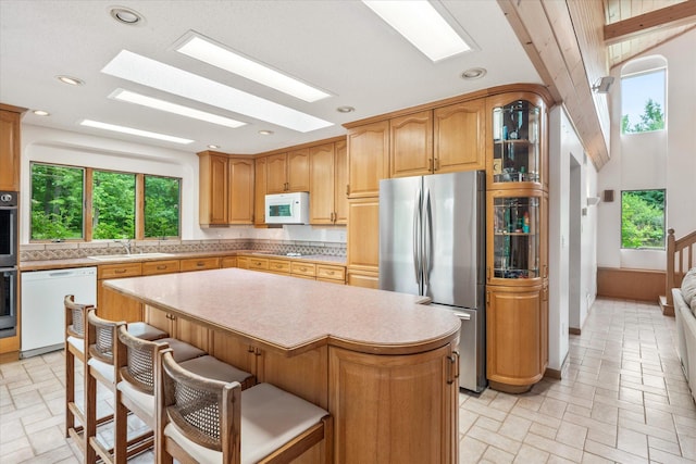 3718 Big Mcgraw Rd, Blaine Twp, WI 54830 - kitchen featuring appliances with stainless steel finishes, light countertops, a center island, a breakfast bar area, and recessed lighting