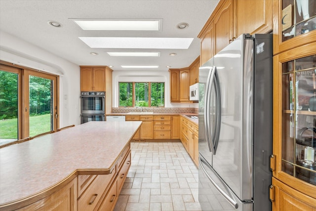 3718 Big Mcgraw Rd, Blaine Twp, WI 54830 - kitchen with stainless steel appliances, light countertops, a skylight, tasteful backsplash, and recessed lighting
