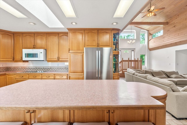 3718 Big Mcgraw Rd, Blaine Twp, WI 54830 - kitchen with white microwave, freestanding refrigerator, a skylight, open floor plan, and black electric cooktop