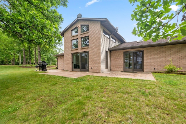 3718 Big Mcgraw Rd, Blaine Twp, WI 54830 - back of house with brick siding, a patio, and a yard