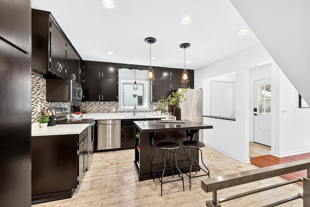 4716 30th Ave S, Minneapolis, MN 55406 - kitchen with stainless steel appliances, light wood-style floors, tasteful backsplash, a breakfast bar area, and recessed lighting