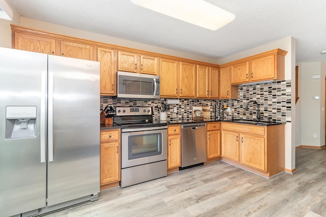 16063 71st Ln NE, Otsego, MN 55330 - kitchen with appliances with stainless steel finishes, dark countertops, light wood finished floors, and tasteful backsplash