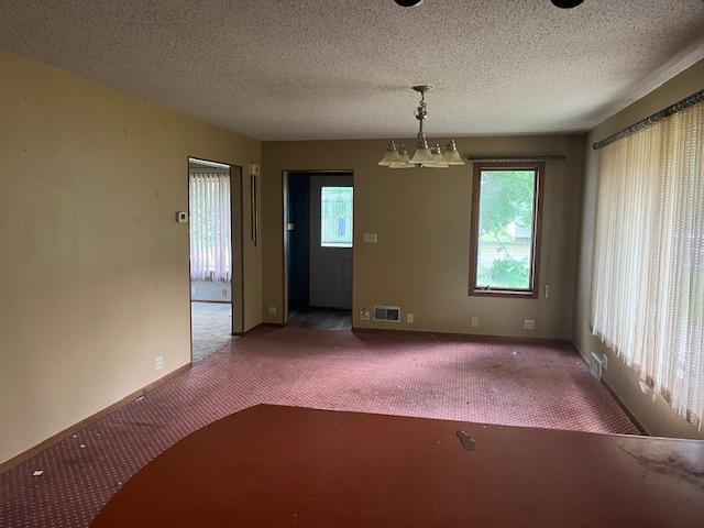 241 S Street W, Amery, WI 54001 - unfurnished dining area with carpet floors and a chandelier