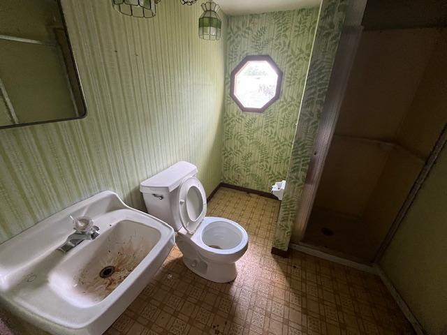 241 S Street W, Amery, WI 54001 - full bathroom featuring wallpapered walls, a stall shower, and tile patterned floors