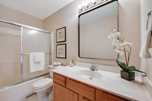 927 Charles Ave, Saint Paul, MN 55104 - full bathroom featuring vanity, shower / bath combination with glass door, and a textured ceiling