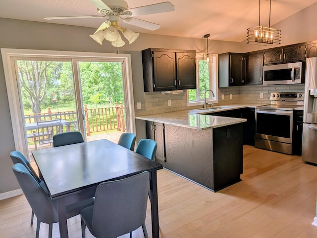 1541 282nd Ln NW, Isanti Twp, MN 55040 - kitchen with appliances with stainless steel finishes, backsplash, a peninsula, light wood-type flooring, and dark brown cabinetry