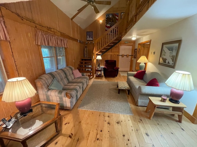 31519 243rd Ave, Moose Creek Twp, MN 56676 - living room featuring stairway, hardwood / wood-style flooring, high vaulted ceiling, wooden walls, and a ceiling fan