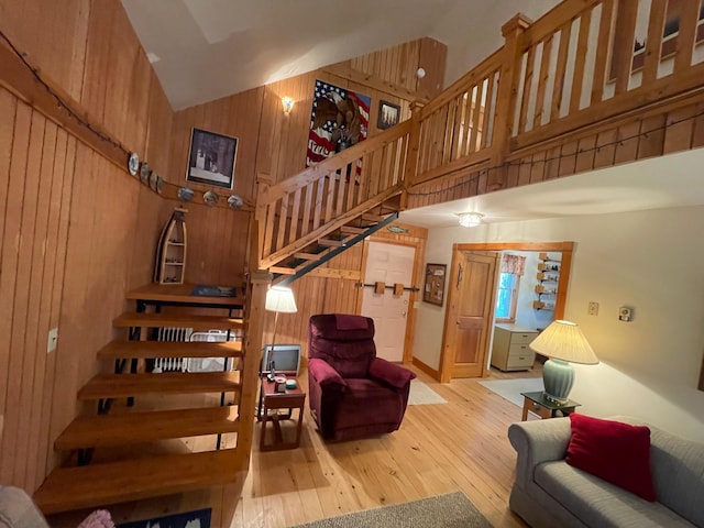 31519 243rd Ave, Moose Creek Twp, MN 56676 - living area with stairs, wood walls, hardwood / wood-style flooring, and high vaulted ceiling
