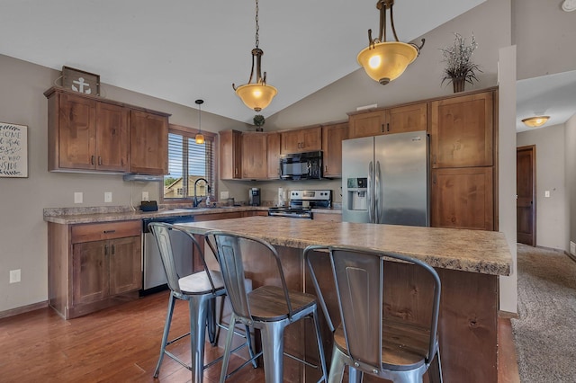 617 Knights Ct, Sartell, MN 56377 - kitchen featuring stainless steel appliances, vaulted ceiling, a center island, decorative light fixtures, and a kitchen bar