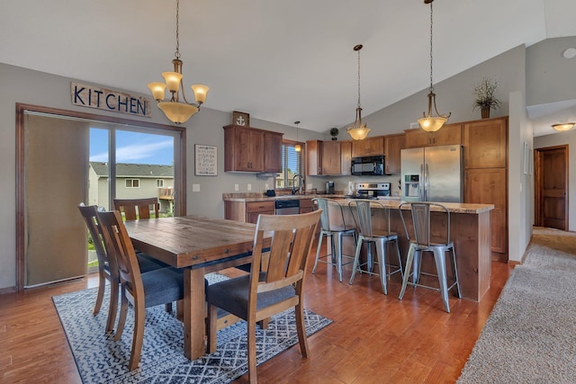 617 Knights Ct, Sartell, MN 56377 - dining area featuring light wood-type flooring, high vaulted ceiling, and a chandelier