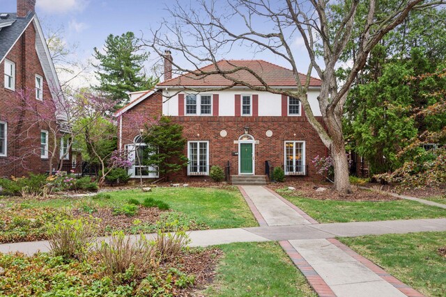 26 Mississippi River Blvd N, Saint Paul, MN 55104 - view of front of property featuring a chimney, a front yard, brick siding, and stucco siding