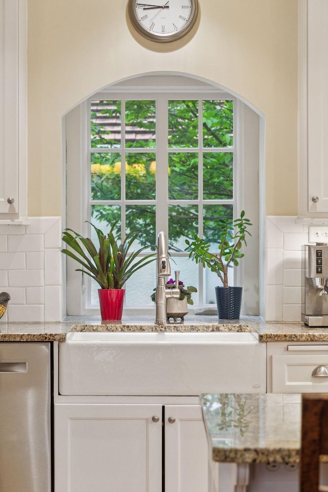 26 Mississippi River Blvd N, Saint Paul, MN 55104 - kitchen with stainless steel dishwasher, decorative backsplash, white cabinets, and light stone counters