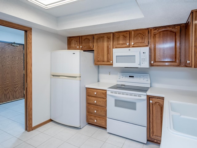 10 Windsor Ct Unit 205, New Brighton, MN 55112 - kitchen with white appliances, light countertops, brown cabinetry, and a raised ceiling