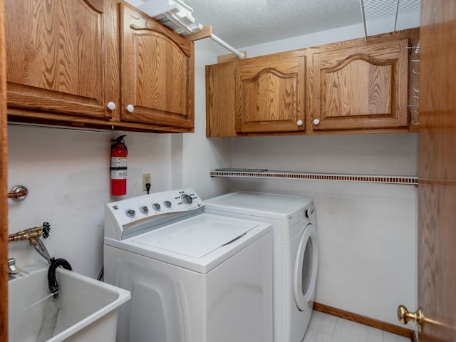 10 Windsor Ct Unit 205, New Brighton, MN 55112 - washroom featuring washing machine and clothes dryer, cabinet space, light tile patterned floors, and a textured ceiling