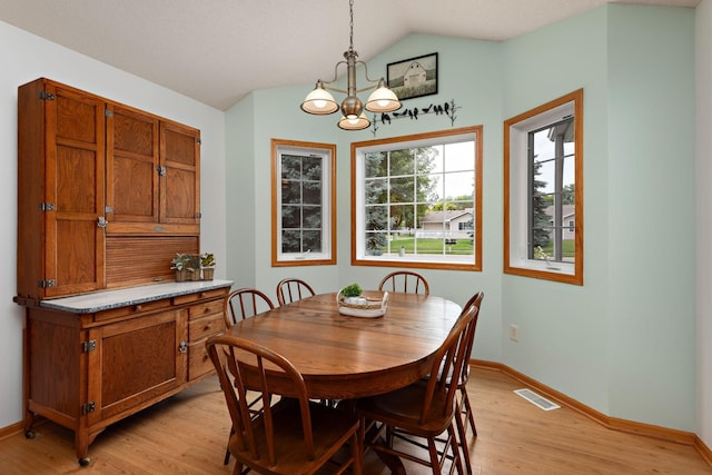 13019 Brookside Ln N, Rogers, MN 55374 - dining area featuring vaulted ceiling, a chandelier, and light wood-style floors