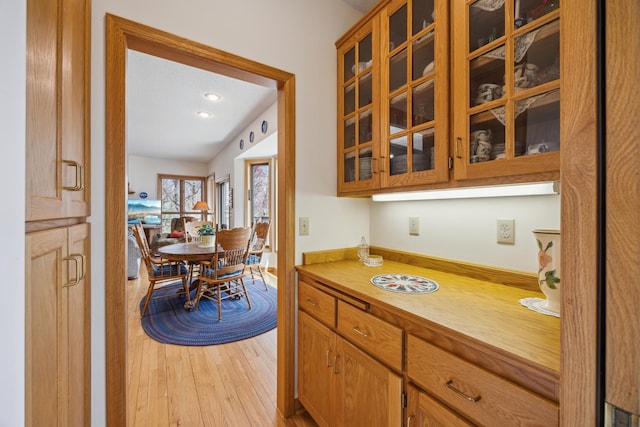 1181 12th Ave NW, New Brighton, MN 55112 - kitchen with light wood-style flooring, light countertops, glass insert cabinets, recessed lighting, and brown cabinets