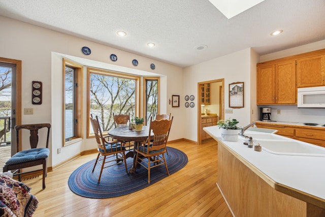 1181 12th Ave NW, New Brighton, MN 55112 - dining space with a skylight, a textured ceiling, light wood-type flooring, and recessed lighting