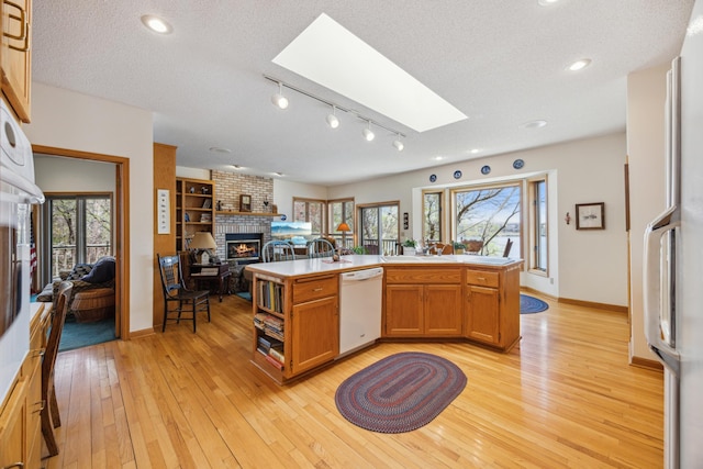 1181 12th Ave NW, New Brighton, MN 55112 - kitchen featuring dishwasher, a fireplace, a skylight, open floor plan, and light countertops