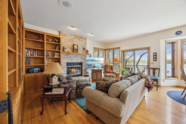 1181 12th Ave NW, New Brighton, MN 55112 - living area with a textured ceiling, light wood-style floors, and a brick fireplace