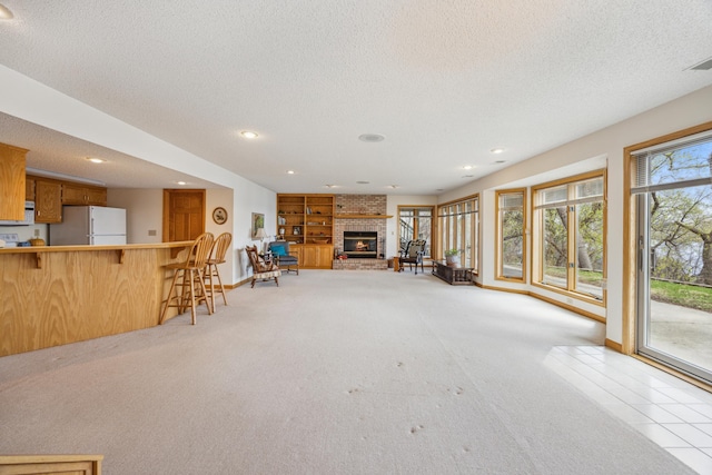 1181 12th Ave NW, New Brighton, MN 55112 - living room featuring a textured ceiling, light colored carpet, recessed lighting, and a brick fireplace