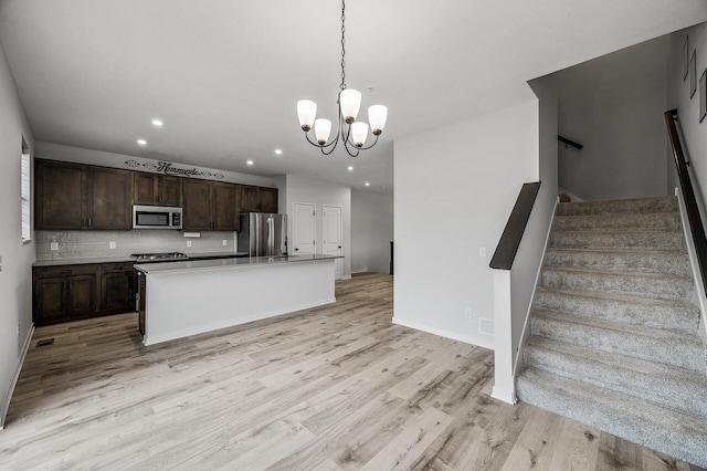 8698 London Cir NE Unit C, Blaine, MN 55449 - kitchen with stainless steel appliances, recessed lighting, dark brown cabinets, light wood-style flooring, and a chandelier