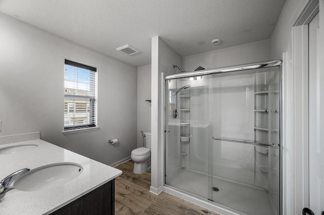 8698 London Cir NE Unit C, Blaine, MN 55449 - bathroom featuring wood finished floors, a shower stall, a textured ceiling, and double vanity
