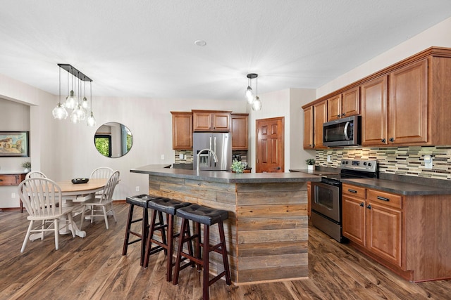 11608 21st St NE, Saint Michael, MN 55376 - kitchen featuring appliances with stainless steel finishes, dark countertops, decorative backsplash, and dark wood-type flooring