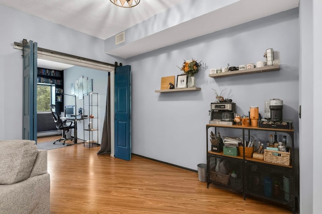 2265 Youngman Ave Unit 207E, Saint Paul, MN 55116 - living room with a barn door, wood finished floors, a baseboard radiator, and an office area
