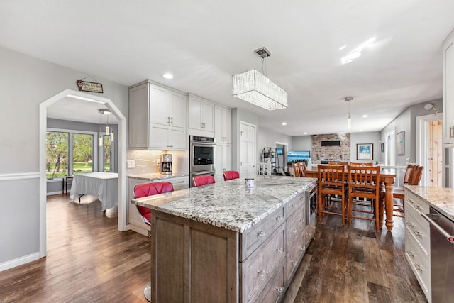8700 Kilbirnie Ter, Brooklyn Park, MN 55443 - kitchen with dark wood-style flooring, decorative backsplash, stainless steel appliances, open floor plan, and recessed lighting