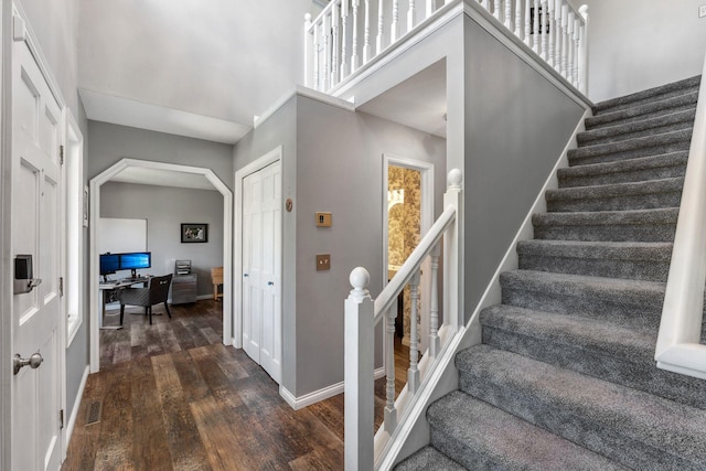 8700 Kilbirnie Ter, Brooklyn Park, MN 55443 - staircase featuring wood finished floors, a high ceiling, and arched walkways