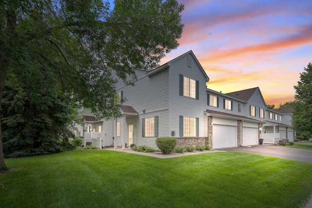17980 69th Pl N, Maple Grove, MN 55311 - view of front of home with a garage, a lawn, asphalt driveway, and brick siding