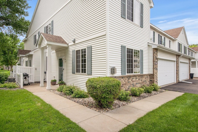 17980 69th Pl N, Maple Grove, MN 55311 - view of home's exterior featuring brick siding, an attached garage, a yard, driveway, and roof with shingles