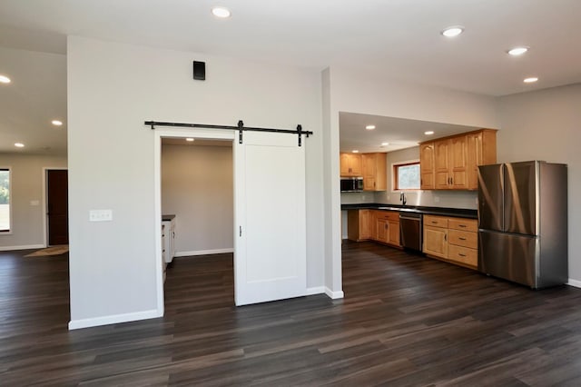 1722 41st Ave NE, Dovre Twp, MN 56201 - kitchen featuring stainless steel appliances, a barn door, dark countertops, dark wood-style flooring, and recessed lighting