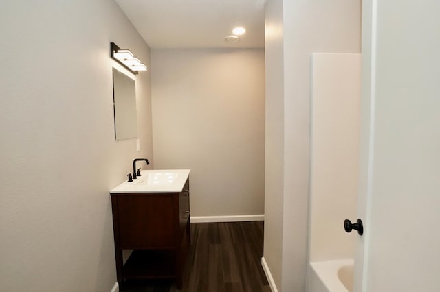 1722 41st Ave NE, Dovre Twp, MN 56201 - bathroom featuring vanity, a tub to relax in, and wood finished floors