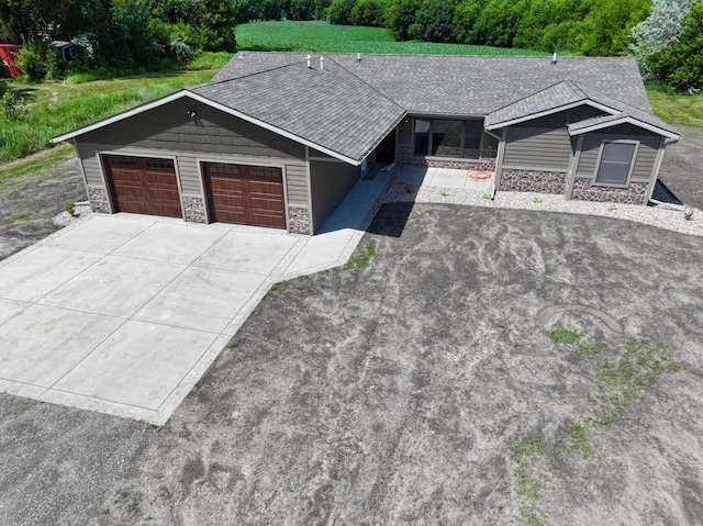 1722 41st Ave NE, Dovre Twp, MN 56201 - ranch-style home featuring stone siding, a garage, driveway, and a shingled roof